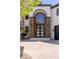 A beautiful front door with stone accents and a lovely arched window above at 9501 Balatta Canyon Ct, Las Vegas, NV 89144