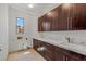 Laundry room featuring custom wood cabinets, marble countertops and stainless steel fixtures at 9501 Balatta Canyon Ct, Las Vegas, NV 89144