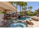 Inviting pool and spa feature a rock waterfall, swim up bar, and covered patio area at 9501 Balatta Canyon Ct, Las Vegas, NV 89144