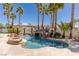 Resort style pool features a rock waterfall, tanning ledge, and fire pit, surrounded by palm trees at 9501 Balatta Canyon Ct, Las Vegas, NV 89144