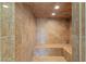 Luxurious walk-in shower featuring floor-to-ceiling tile work and built-in bench seating at 9501 Balatta Canyon Ct, Las Vegas, NV 89144