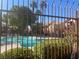 Community pool with a partially obscured view through iron fencing at 1050 E Cactus Ave # 2110, Las Vegas, NV 89183