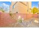 The backyard features a rock garden, a mature tree, and a brick wall providing privacy and charm at 10525 Shiny Skies Dr, Las Vegas, NV 89129