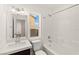 Well lit bathroom with a single sink vanity, a bathtub with shower, and white tile at 10525 Shiny Skies Dr, Las Vegas, NV 89129