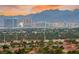 Stunning cityscape view of the skyline is visible over a canopy of lush, green trees at 10525 Shiny Skies Dr, Las Vegas, NV 89129