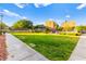 Beautiful community park featuring manicured lawns, mature trees, a gazebo, and walkable sidewalks under a bright blue sky at 10525 Shiny Skies Dr, Las Vegas, NV 89129