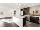 Bright, open kitchen with dark wood cabinets, stainless steel appliances, and a large center island with white countertop at 10525 Shiny Skies Dr, Las Vegas, NV 89129