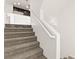 Carpeted staircase featuring a white handrail and minimalist design, offering a stylish transition between floors at 10525 Shiny Skies Dr, Las Vegas, NV 89129