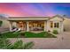 Backyard view featuring a covered patio, lounge area, and low-maintenance landscaping under a colorful sunset at 10713 Shoalhaven Dr, Las Vegas, NV 89134