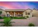 Charming backyard featuring a covered patio, artificial turf, desert landscaping, and outdoor seating at sunset at 10713 Shoalhaven Dr, Las Vegas, NV 89134