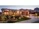 Beautiful single-story home with a well-manicured front yard and desert landscaping at dusk at 10713 Shoalhaven Dr, Las Vegas, NV 89134