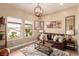Cozy living room with a leather sofa, decorative art, and large windows at 10713 Shoalhaven Dr, Las Vegas, NV 89134