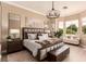 Luxurious main bedroom with a king-size bed, modern chandelier, and lots of light at 10713 Shoalhaven Dr, Las Vegas, NV 89134