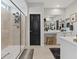Bathroom with a glass shower, black door, and large vanity with ample lighting at 10954 Free Flow Pl, Las Vegas, NV 89138