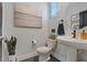 Bathroom featuring a pedestal sink, toilet, beach art, and decorative touches at 10954 Free Flow Pl, Las Vegas, NV 89138