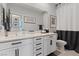Bright bathroom featuring a white vanity with modern hardware and a shower with gray and white curtain at 10954 Free Flow Pl, Las Vegas, NV 89138