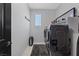 Laundry room with modern machines, a sleek design, and organized storage at 10954 Free Flow Pl, Las Vegas, NV 89138
