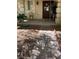 Inviting covered porch with decorative plants and a welcoming wreath on the front door creates a warm entrance at 11021 Pentland Downs St, Las Vegas, NV 89141