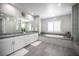 Bright bathroom with double vanity, soaking tub, and marble shower at 12018 Vento Forte Ave, Las Vegas, NV 89138