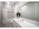 Modern bathroom with a white vanity, large mirror, shower with a white curtain, and gray tile flooring at 12018 Vento Forte Ave, Las Vegas, NV 89138