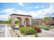 Beautiful community entrance featuring an arched entryway, lush landscaping, and a welcoming atmosphere at 12018 Vento Forte Ave, Las Vegas, NV 89138