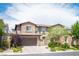 Charming two-story home showcasing a brick facade, well-manicured landscaping, and a spacious two-car garage at 12018 Vento Forte Ave, Las Vegas, NV 89138