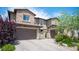 Beautiful home exterior featuring brick accents, a paved driveway, a gated courtyard, and a two-car garage at 12018 Vento Forte Ave, Las Vegas, NV 89138