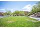 Well maintained green space in a planned community featuring lush grass, sidewalk, benches, and landscaping at 12018 Vento Forte Ave, Las Vegas, NV 89138