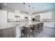 Bright kitchen with white cabinets, a large granite island with seating, and modern appliances at 12018 Vento Forte Ave, Las Vegas, NV 89138