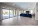 Expansive living room showcasing gray tile flooring, large windows, and a comfortable seating area at 12018 Vento Forte Ave, Las Vegas, NV 89138