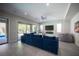 Stylish living room featuring tile flooring, a large sofa, recessed lighting, and a sliding glass door to the outside at 12018 Vento Forte Ave, Las Vegas, NV 89138