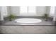 Close up of soaking tub with gray countertops and tiled surround at 12018 Vento Forte Ave, Las Vegas, NV 89138