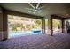 This covered patio features brick flooring and an outdoor living space with a pool at 12018 Vento Forte Ave, Las Vegas, NV 89138