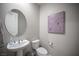 Elegant powder room with pedestal sink, round mirror, and modern fixtures at 12018 Vento Forte Ave, Las Vegas, NV 89138