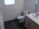 Bathroom featuring a single sink vanity, toilet, wood-look flooring, and bright natural light at 1401 N Michael Way # 244, Las Vegas, NV 89108