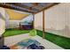 Backyard features a hot tub, artificial grass, and shade sails for outdoor enjoyment at 167 Thunder Plains Way, Henderson, NV 89012