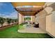 Inviting backyard patio featuring a pergola, artificial turf, and a cozy outdoor dining area at 167 Thunder Plains Way, Henderson, NV 89012