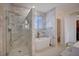 Spa-like bathroom featuring a walk-in shower, freestanding tub, marble finishes, and a large window at 167 Thunder Plains Way, Henderson, NV 89012
