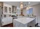 Modern kitchen with white cabinets, stainless steel appliances, large center island, and stylish pendant lights at 167 Thunder Plains Way, Henderson, NV 89012