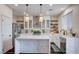 Bright kitchen features stainless appliances, white cabinets, marble countertops, island, and open shelving at 167 Thunder Plains Way, Henderson, NV 89012