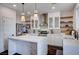 Bright kitchen features stainless appliances, white cabinets, marble countertops, island, and open shelving at 167 Thunder Plains Way, Henderson, NV 89012
