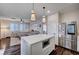 Open-concept kitchen with island, stainless steel refrigerator, and sight lines to the living room at 167 Thunder Plains Way, Henderson, NV 89012