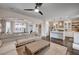 Spacious living room with modern fan, wood floors, neutral tones, and access to the dining and kitchen area at 167 Thunder Plains Way, Henderson, NV 89012