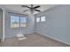 Well-lit bedroom features plush carpet, ceiling fan, and dual windows overlooking trees at 1717 Double Arch Ct, Las Vegas, NV 89128