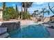 Backyard pool with stone waterfall feature and lounge area with grill at 1717 Double Arch Ct, Las Vegas, NV 89128