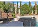A backyard pool and patio with two chairs, landscaping, and hardscaping at 1717 Double Arch Ct, Las Vegas, NV 89128