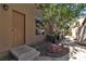 Side exterior view of a private entrance with a manicured stone landscape and shade tree at 1717 Double Arch Ct, Las Vegas, NV 89128