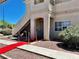 Condominium entrance with stairs and red carpet, complemented by desert landscaping and a welcoming ambiance at 1881 W Alexander Rd # 1128, North Las Vegas, NV 89032