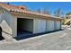 Exterior view of multiple private garages, painted white with metal garage doors under a terracotta tiled roof at 1881 W Alexander Rd # 1128, North Las Vegas, NV 89032