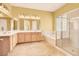 Bathroom featuring double sink vanity, soaking tub, and glass-enclosed shower at 2318 Shorewood Hills Ave, Henderson, NV 89052
